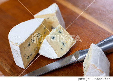 Pieces of soft blue cheese and knife on wooden cutting board Pieces of soft blue cheese and knife on wooden cutting board 138839377