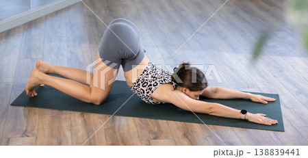Sporty young woman performing advanced yoga posture in studio Sporty young woman performing advanced yoga posture in studio 138839441