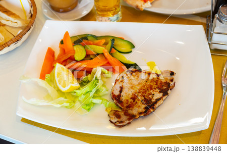 Roasted pork chop served with stewed vegetables. Italian cuisine 138839448