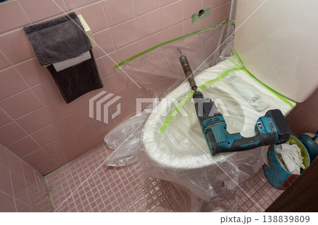 トイレの壁面に穴あけ施工を行う設備工事の作業現場 トイレの壁面に穴あけ施工を行う設備工事の作業現場 138839809