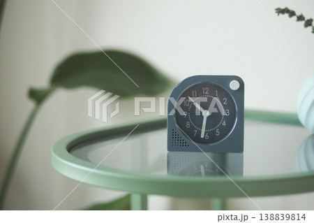 Simple clock on a green table in a bright room Simple clock on a green table in a bright room 138839814