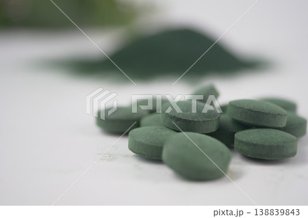 Green tablets and powder on a white surface in a kitchen 138839843