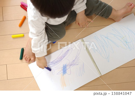 お家のフローリングでスケッチブックにクレヨンで線を描く子供 お家のフローリングでスケッチブックにクレヨンで線を描く子供 138841047