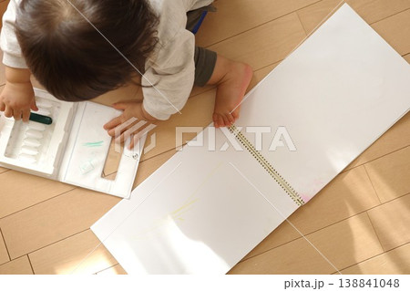 家のフローリングでスケッチブックにお絵かきした後、クレヨンを片付ける子供の手元 家のフローリングでスケッチブックにお絵かきした後、クレヨンを片付ける子供の手元 138841048