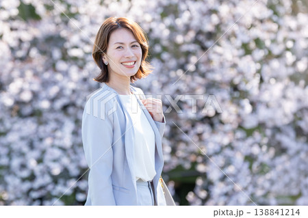 桜並木を歩くミドルの女性 138841214