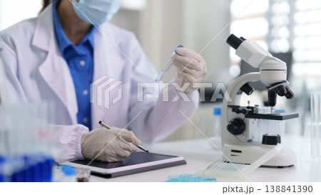 Asian woman scientist conducts lab research analyzes data using tablet microscope develops innovative medical solutions in modern science facility Asian woman scientist conducts lab research analyzes data using tablet microscope develops innovative medical solutions in modern science facility 138841390