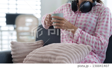 Adult woman pajamas home relaxing holding mug headphones cozy morning lifestyle concept comfortable domestic scene leisure activity wellbeing moment Adult woman pajamas home relaxing holding mug headphones cozy morning lifestyle concept comfortable domestic scene leisure activity wellbeing moment 138841407