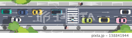 Above view of many cars are stopped at the red light indicating a pedestrian crossing. People are crossing the street at the crosswalk for safety. Sidewalks and trees along the side of the road. Above view of many cars are stopped at the red light indicating a pedestrian crossing. People are crossing the street at the crosswalk for safety. Sidewalks and trees along the side of the road. 138841944