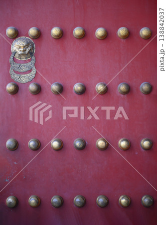 Rivets and lion-shaped handle on gates of 15 century Forbidden City in Beijing, China 138842037