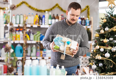 Interested nice bearded man choosing gifts for New Year in household department of supermarket Interested nice bearded man choosing gifts for New Year in household department of supermarket 138842089