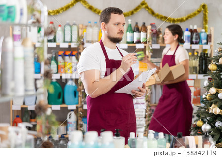 Man seller with woman assistant taking inventory in store 138842119