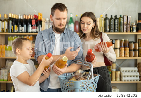 Young family with little son scanning QR on bottle of juice in supermarket Young family with little son scanning QR on bottle of juice in supermarket 138842202