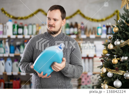 Man choosing detergent while shopping in Christmas decorated store 138842224