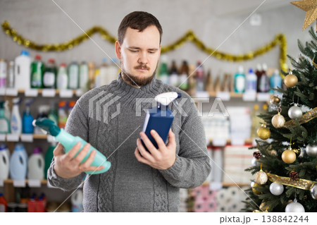 On New Year Eve, man choose and buy kitchen cleaner spray 138842244