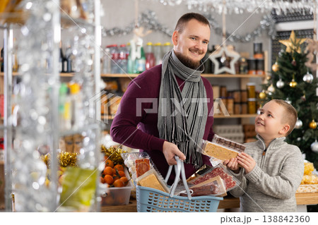 Father and son shopping for holiday celebration in festive market Father and son shopping for holiday celebration in festive market 138842360