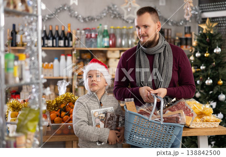 Young man with son choosing products in grocery store 138842500