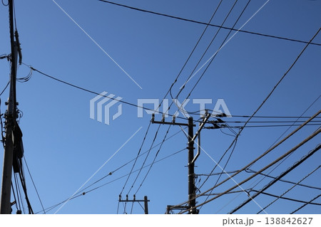 快晴の空にそびえ立つ電柱と電線： 雲ひとつない、クリーンな風景。 138842627