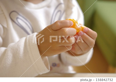 家で一生懸命みかんの皮を剥く子供の手元 家で一生懸命みかんの皮を剥く子供の手元 138842732