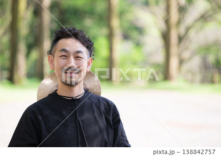 新緑の屋外キャンプ場で笑顔のアウトドアレジャーやお出かけイメージの日本人男性カメラ目線 138842757