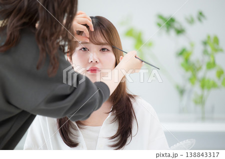 ヘアメイク中の女性モデルと美容師撮影準備シーン　や美容室でのヘアセットなどのイメージ 138843317