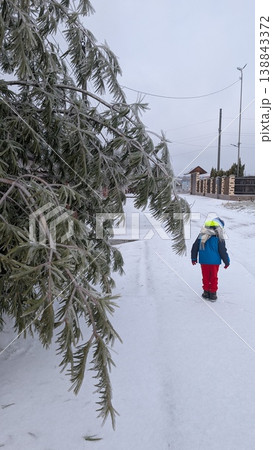 Child moves along snowcovered path wearing bright clothing Child moves along snowcovered path wearing bright clothing 138843372