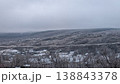 Silent snowblanketed hills under cloudy sky with distant fog 138843378