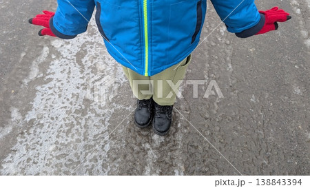 Child in blue jacket balancing on puddle playful explorer Child in blue jacket balancing on puddle playful explorer 138843394