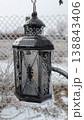 Serene winter scene with frostcovered lantern suspended by icy fence 138843406