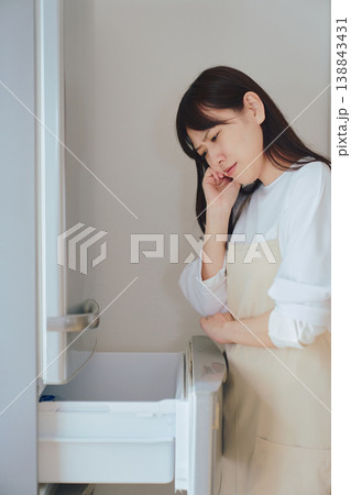冷蔵庫の中を見て悩む女性 食材不足や献立に困る日常のイメージ 138843431