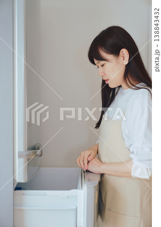 冷蔵庫の中を見て悩む女性 食材不足や献立に困る日常のイメージ 冷蔵庫の中を見て悩む女性 食材不足や献立に困る日常のイメージ 138843432