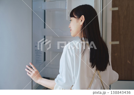 冷蔵庫を開けて中身を確認する女性 日常生活や食事準備のシーン 冷蔵庫を開けて中身を確認する女性 日常生活や食事準備のシーン 138843436
