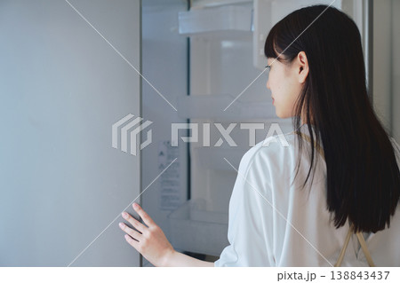 冷蔵庫を開けて中身を確認する女性 日常生活や食事準備のシーン 冷蔵庫を開けて中身を確認する女性 日常生活や食事準備のシーン 138843437