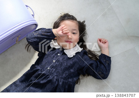 床に寝転んで眠そうなランドセルの日本人の女の子 床に寝転んで眠そうなランドセルの日本人の女の子 138843707