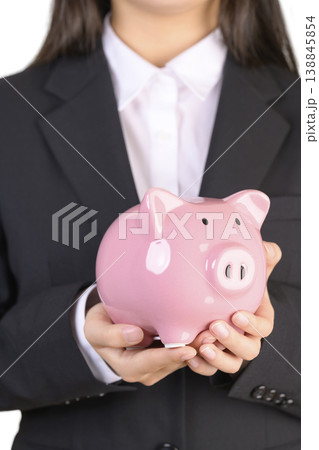 豚の貯金箱を持つスーツを着た女性 138845854
