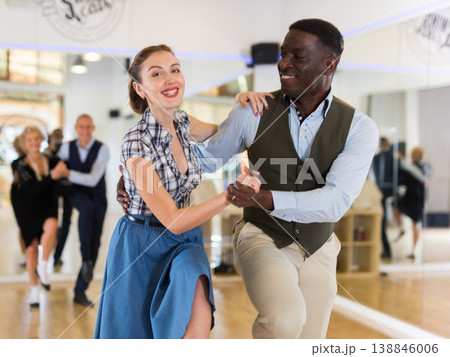 Woman with african man practising charleston dancing 138846006