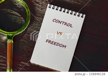 A white spiral-bound notebook displays the words Control versus Freedom 138846116
