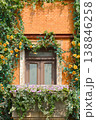 Sunlit Brick Window With Flower Box, Ivy And Yellow Roses On A Charming Balcony 138846258