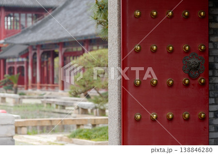 Traditional Chinese Red Temple Door With Brass Studs Framing Historic Courtyard Architecture Traditional Chinese Red Temple Door With Brass Studs Framing Historic Courtyard Architecture 138846280