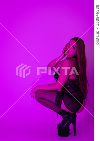 Side view sexy woman femme fatale wearing lingerie, stripper heels squatting and looking at camera Side view sexy woman femme fatale wearing lingerie, stripper heels squatting and looking at camera 138846588