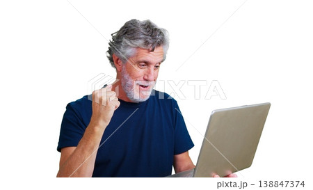 Mature man expressing excitement and victory watching content on a laptop Mature man expressing excitement and victory watching content on a laptop 138847374