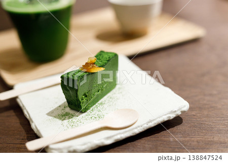 Closeup of fresh matcha terrine with cup of matcha on wooden background. Closeup of fresh matcha terrine with cup of matcha on wooden background. 138847524