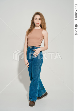 Woman poses in casual outfit with light background in modern indoor space during day 138847664