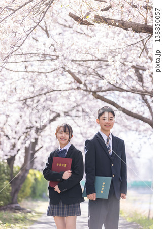 満開の桜の中で卒業証書を持つ制服の男女の学生 満開の桜の中で卒業証書を持つ制服の男女の学生 138850057