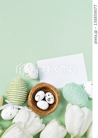 White tulips and Easter eggs on mint background with blank card 138850077