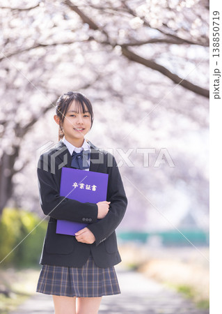桜の下で卒業証書を持つ制服の女の子 138850719