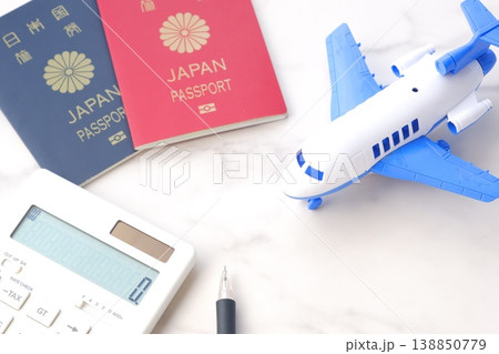 電卓と飛行機、パスポート(10年用赤色と、5年用紺色)で、海外旅行を計画しているイメージ 電卓と飛行機、パスポート(10年用赤色と、5年用紺色)で、海外旅行を計画しているイメージ 138850779