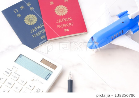 電卓と飛行機、パスポート(10年用赤色と、5年用紺色)で、海外旅行を計画しているイメージ 電卓と飛行機、パスポート(10年用赤色と、5年用紺色)で、海外旅行を計画しているイメージ 138850780