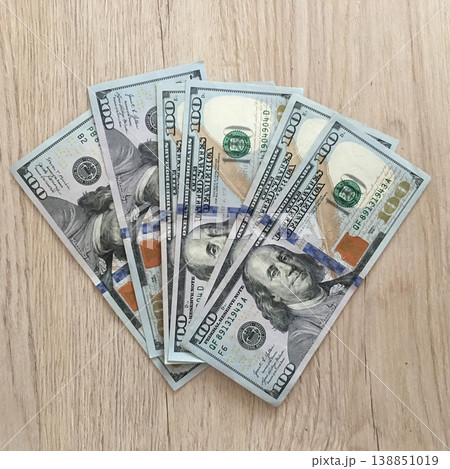 Fresh stacks of hundred dollar bills arranged on a wooden surface during the day in an indoor setting Fresh stacks of hundred dollar bills arranged on a wooden surface during the day in an indoor setting 138851019