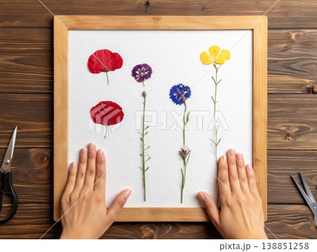 野花を木製フレームで丁寧に押し花にする 138851258