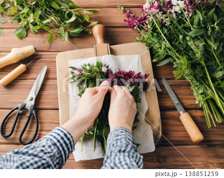 野花を木製フレームで丁寧に押し花にする 138851259